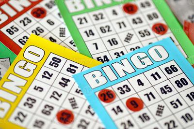 Many-colorful-bingo-boards-or-playing-cards-for-winning-chips-classic-us-or-canadian-five-to-five-bingo-cards-on-bright-background-photo